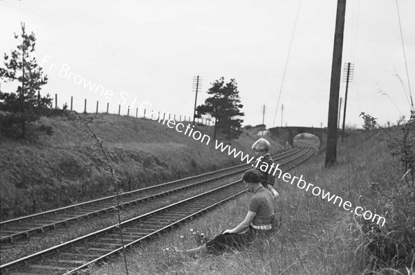 BOYS WATCHING AND WAITING AT RAILWAY EMBANKMENT